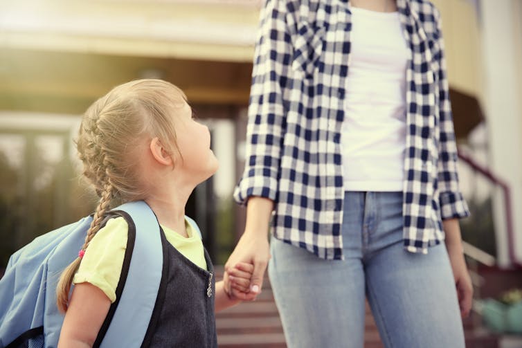 Mother walking little girl to school.