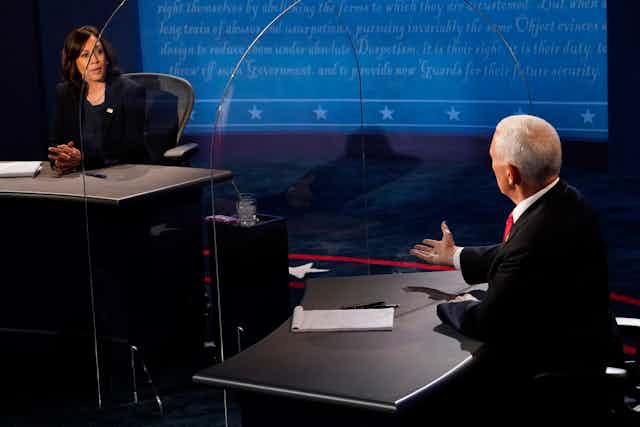 Harris and Pence face each other on the debate stage through plexiglass barrier.