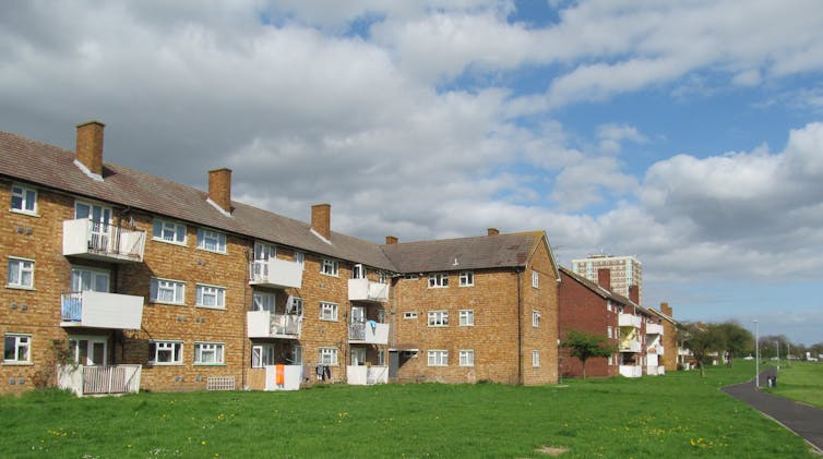 Landscape photograph of low block of flats with grass in front
