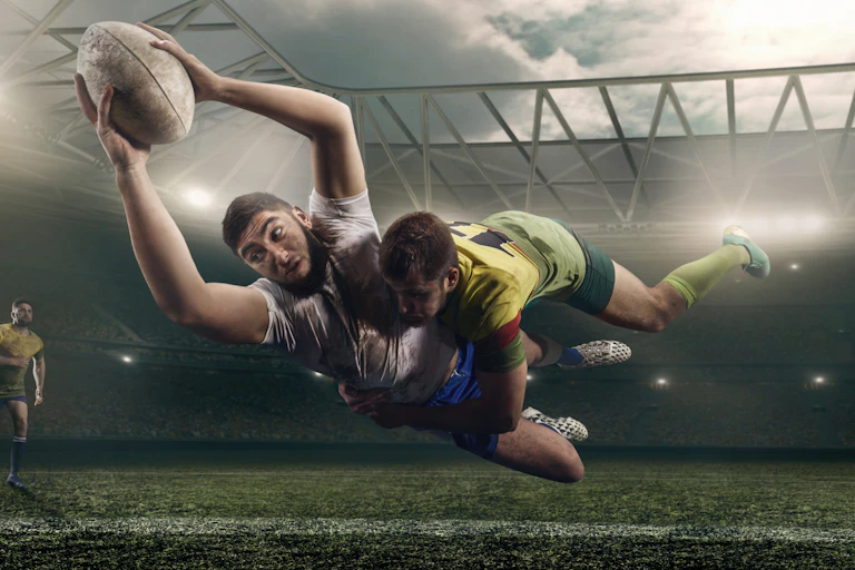 Ruby player scoring try while being tackled.