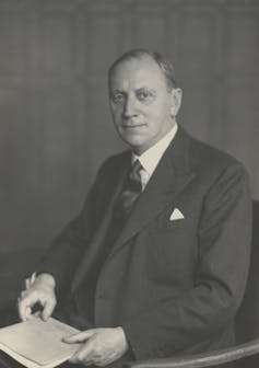 Painting of a middle-aged man in a suit holding a book.