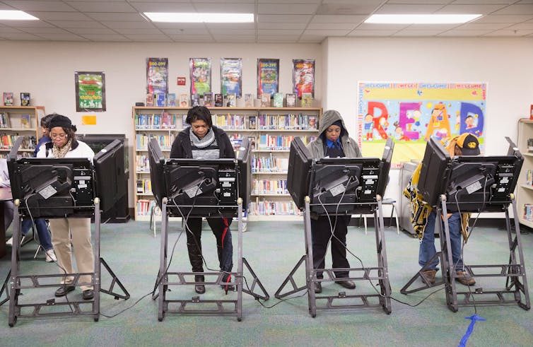 Four voters who are Black casting ballots.