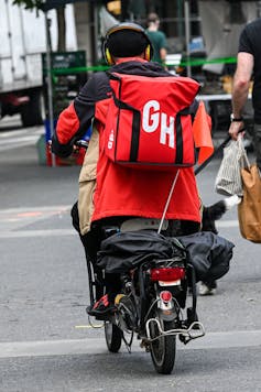 A Grubhub delivery man speeds off on his electric bike to make a delivery on May 29 in New York City.