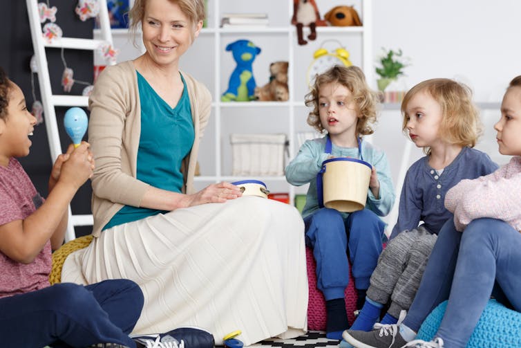 Teacher with kids at childcare.