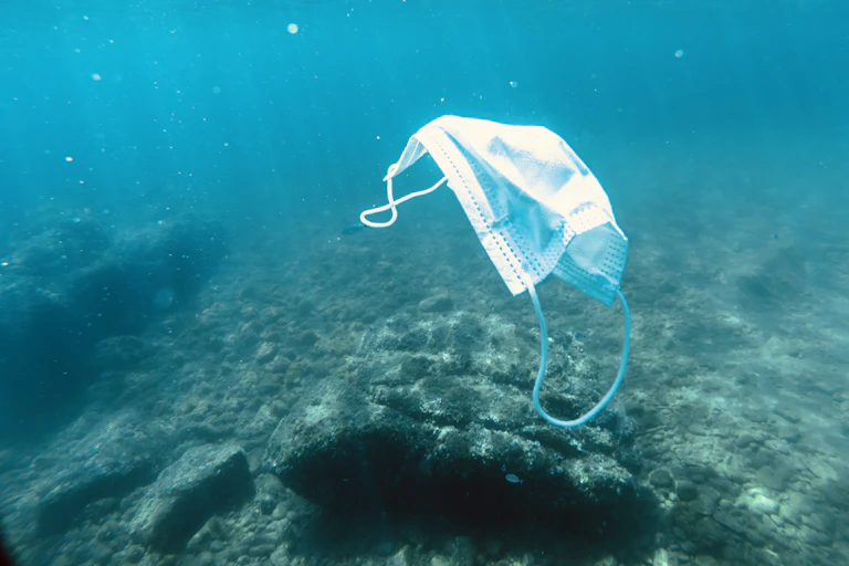 A face mask floating in the ocean