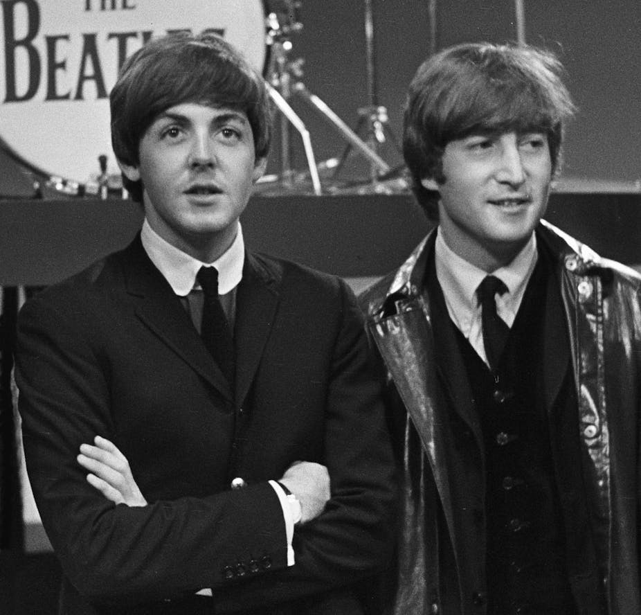 Paul McCartney, left, John Lennon, right, in front of The Beatles drum riser