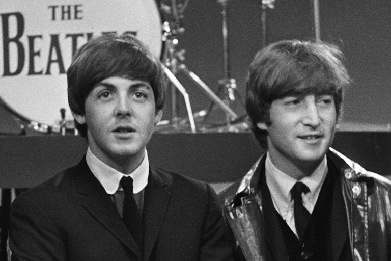 Paul McCartney, left, John Lennon, right, in front of The Beatles drum riser