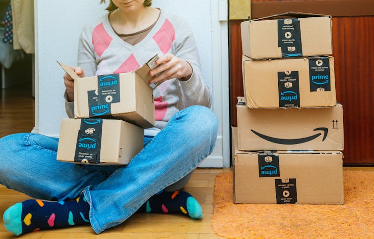 Woman with lots of cardboard delivery boxes.