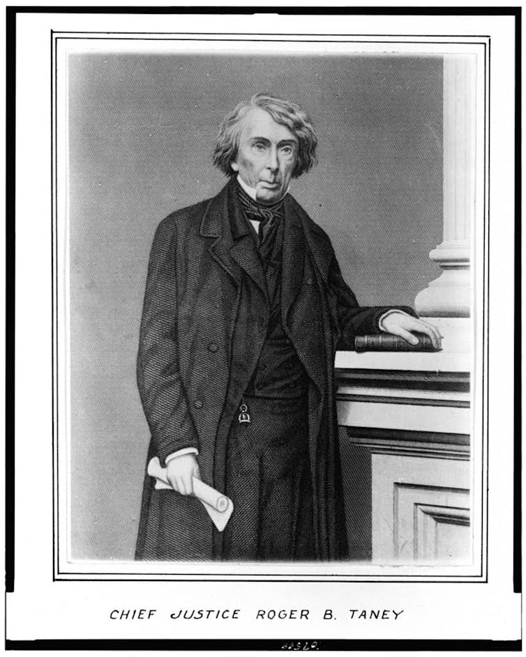 A black and white protrait of a white man wearing an elaborate suit and holding a book.