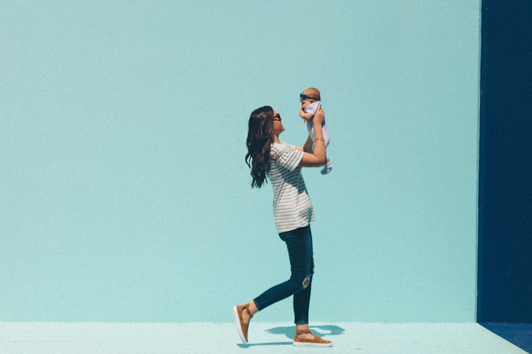 A woman walks with a baby.