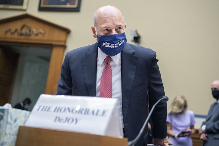 DeJoy arrives speak in the House of Representatives wearing a USPS face mask