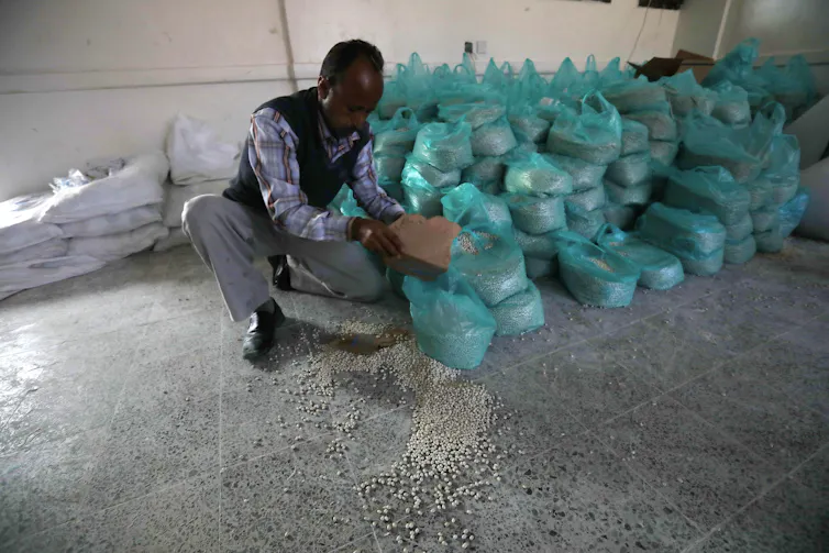 Man puts food aid into plastic bags.