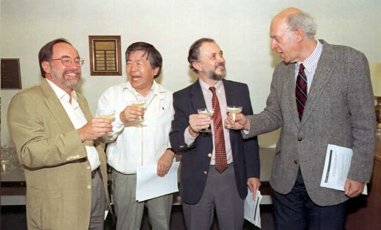 Four men toast each other