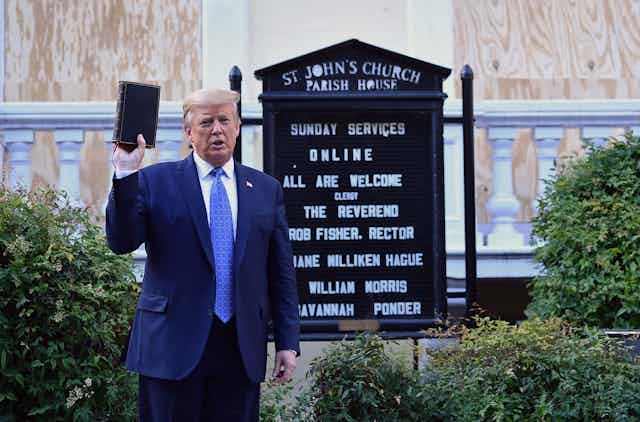 Donald Trump holds a Bible outside of St John's Episcopal church across Lafayette Park in Washington, DC.