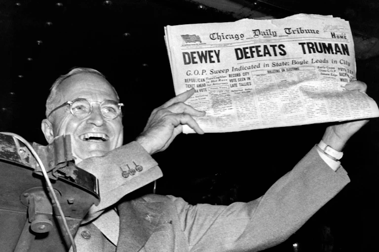 Harry Truman holding a newspaper with the headline "DEWEY DEFEATS TRUMAN"