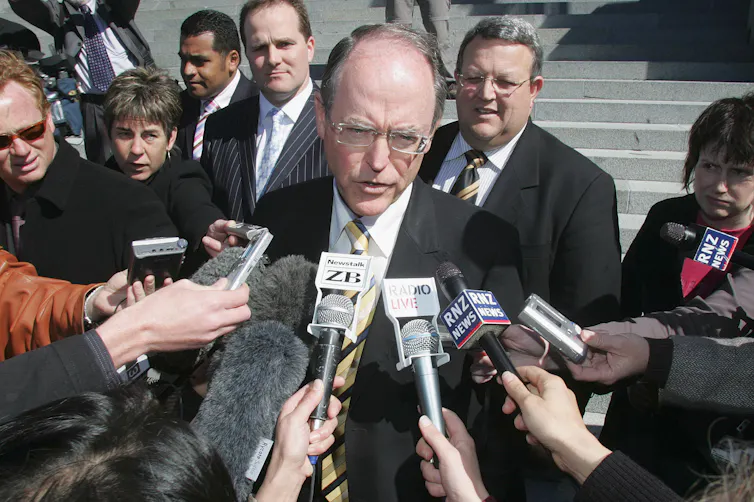 man speaking into microphones