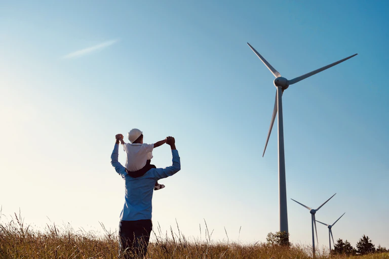 Man and child look at wind turbines