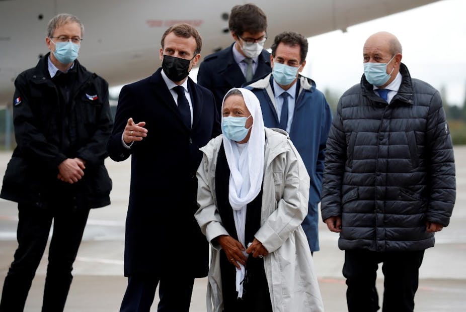 Le président français Emmanuel Macron accueille Sophie Petronin aux côtés du ministre français des affaires européennes et étrangères Jean-Yves Le Drian 
