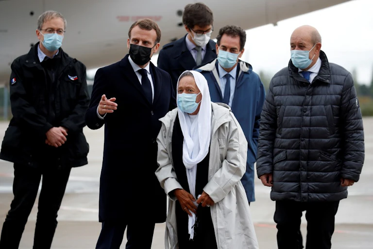 Le président français Emmanuel Macron accueille Sophie Petronin aux côtés du ministre français des affaires européennes et étrangères Jean-Yves Le Drian