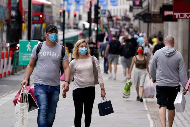 Couple wearing masks on busy shopping street