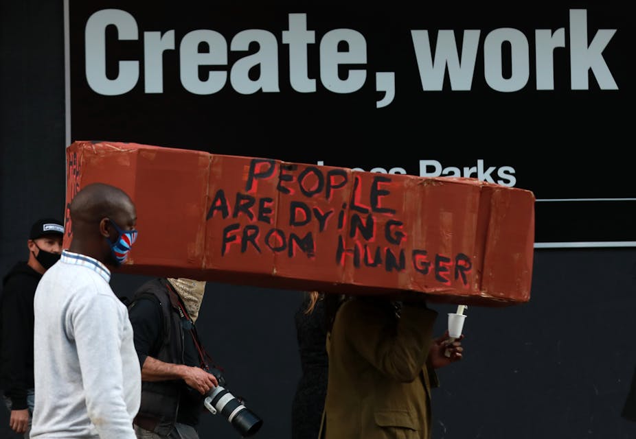 Protestors carrying a make-shift coffin with the words: "people are dying from hunger".