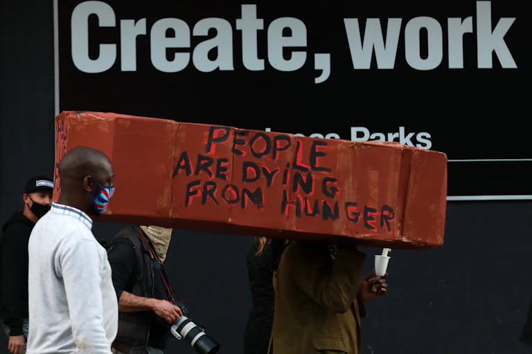 Protestors carrying a make-shift coffin with the words: "people are dying from hunger".
