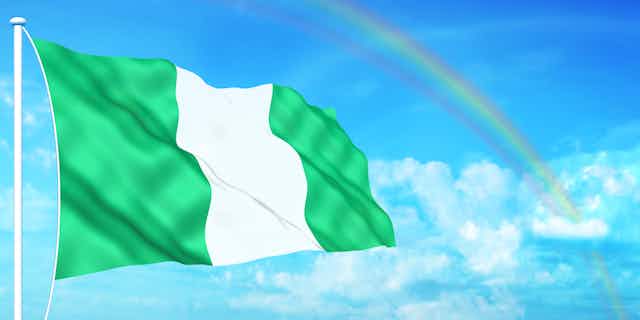 An illustration of a Nigerian flag flying, with clouds and a rainbow in the background