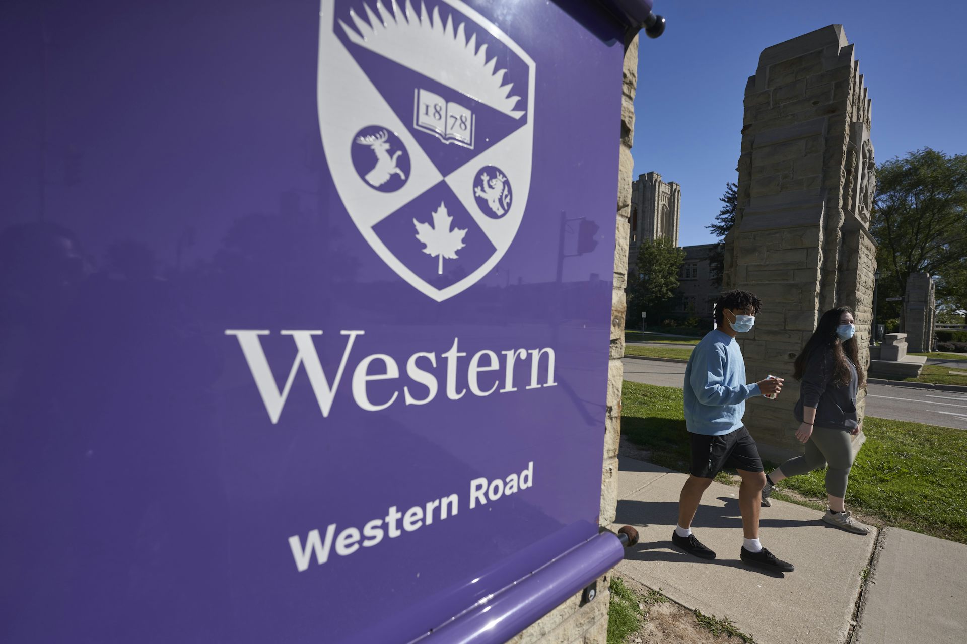 Students walk through a gate at Western University.
