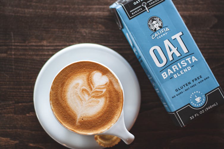 Oat milk carton beside a coffee