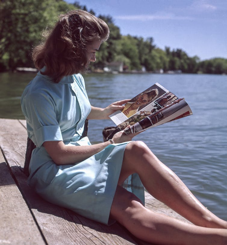 A 1950s woman reads a magazine