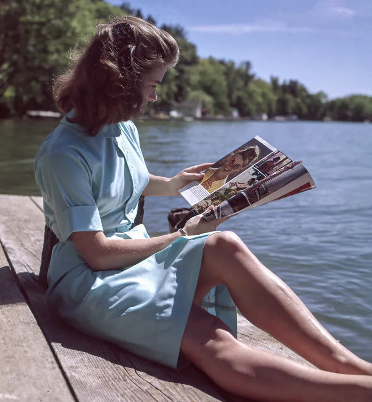 A 1950s woman reads a magazine