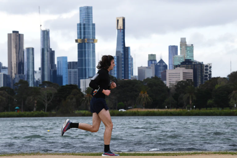 Person running around Albert Park Lake