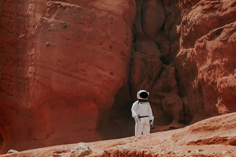 Una persona con traje de astronauta en un paisaje desértico.