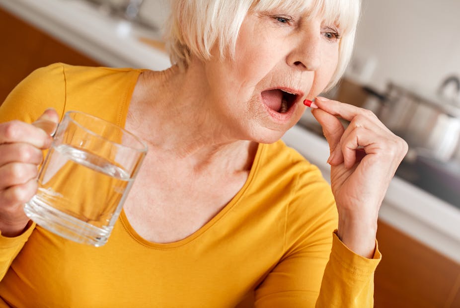 Older woman takes her medication.