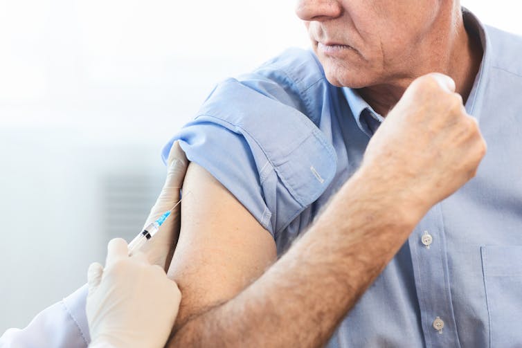 Older man receiving a vaccination.