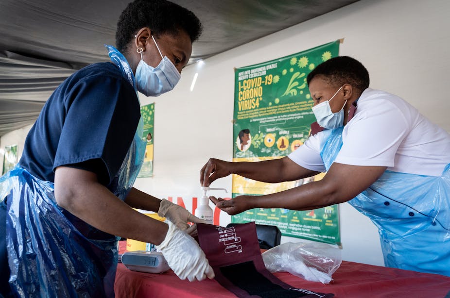 Nurses sanitise their hands and their tools after screening a patient in Johannesburg, South Africa.
