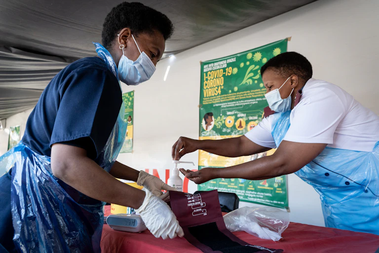 Nurses sanitise their hands and their tools after screening a patient in Johannesburg, South Africa.
