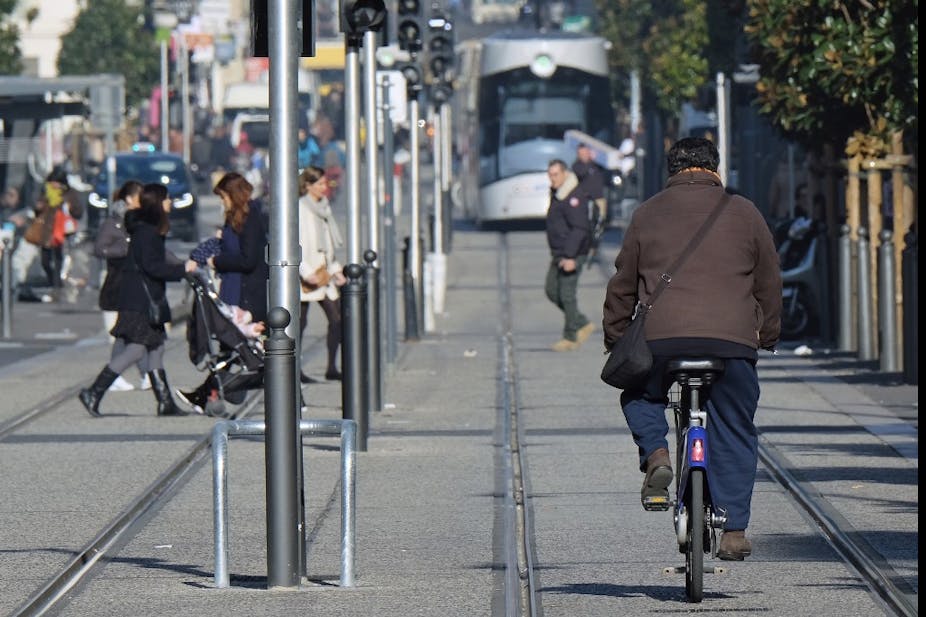 Un homme conduit un vélo à côté d'une ligne de tramway de la ville, le 24 janvier 2017, à Marseille.