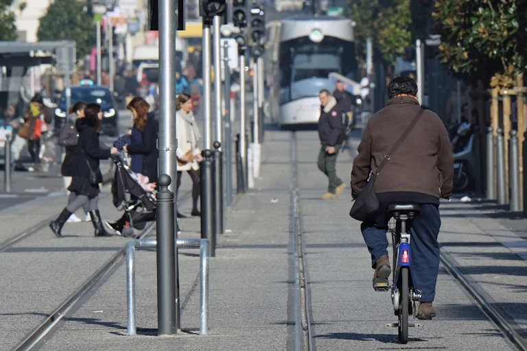 Un homme conduit un vélo à côté d'une ligne de tramway de la ville, le 24 janvier 2017, à Marseille.