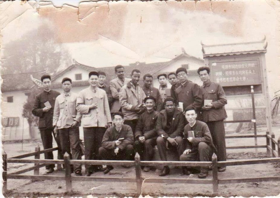 Group of men outdoors, backdrop of Chinese style buildings, black and white vintage photo