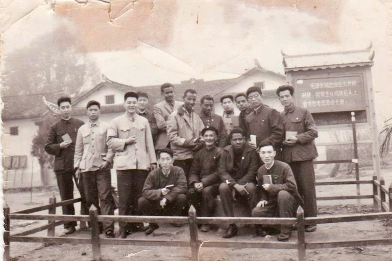 Group of men outdoors, backdrop of Chinese style buildings, black and white vintage photo