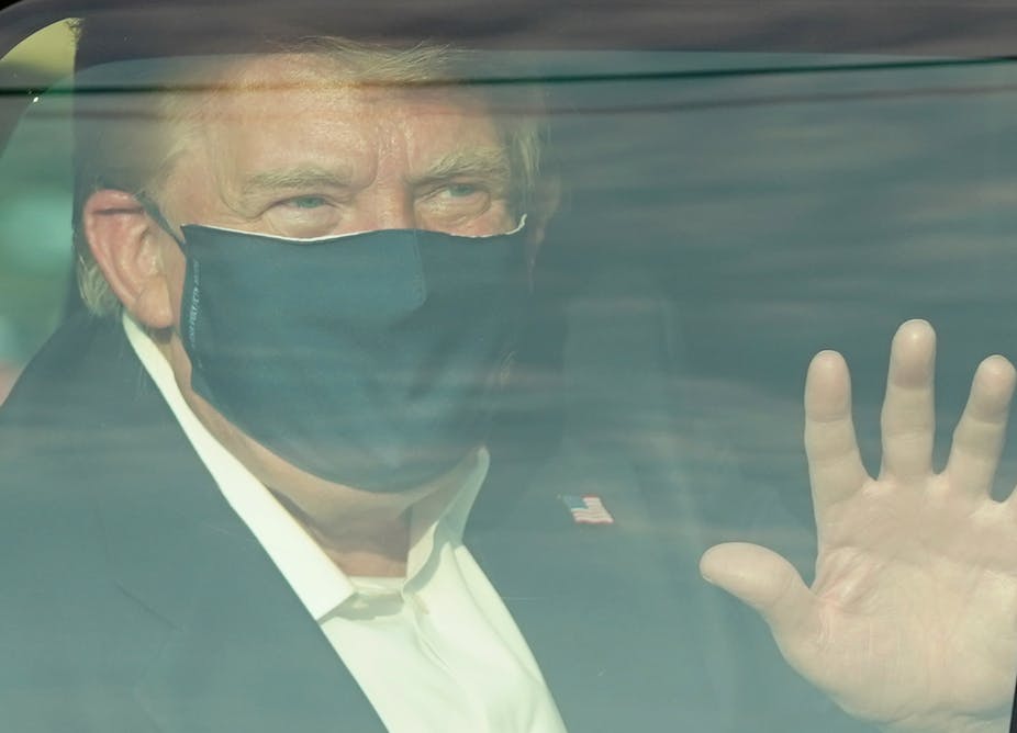 President Trump waves to supporters as he drives drives past them in a motorcade outside of Walter Reed Medical Center.