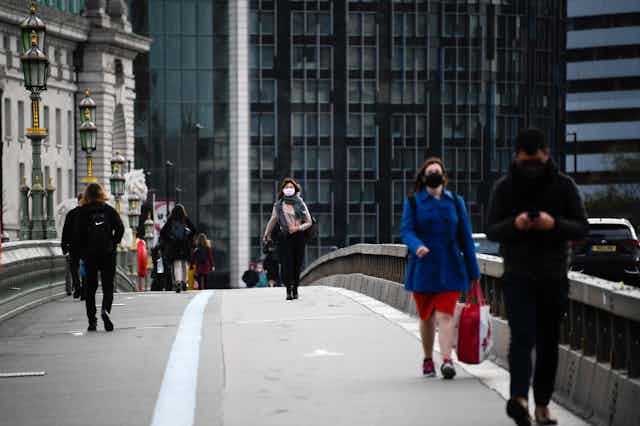 People wearing masks crossing Westminster Bridge, London.
