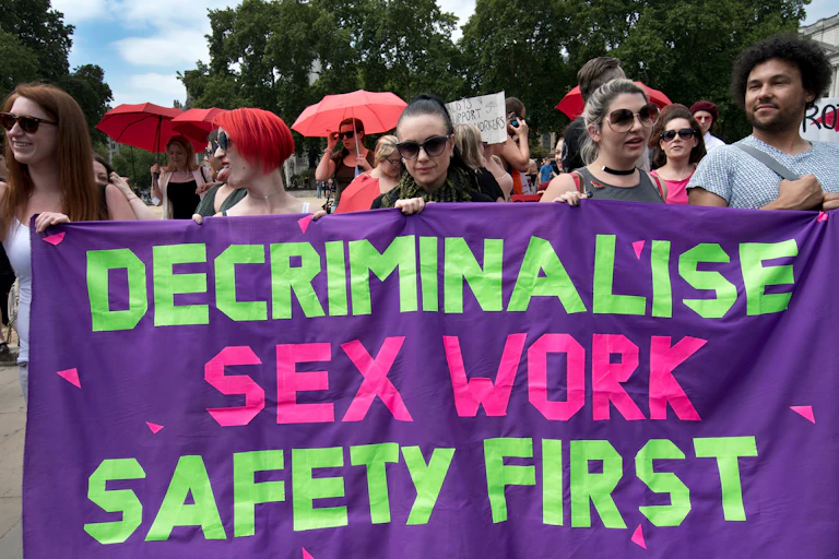 Protest banner: 'decriminalise sex work, safety first'