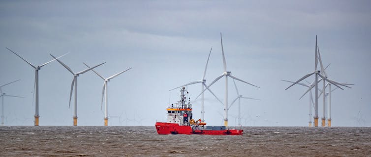 Boris Johnson's offshore wind pledge is positive, but protecting UK jobs requires more 14 A red ship passes in front of wind turbines.