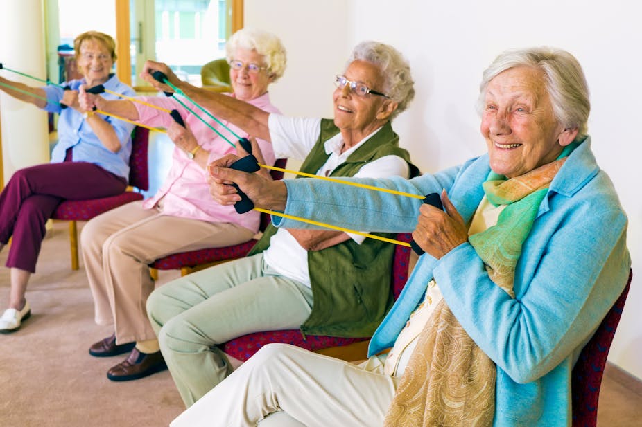 Elderly women exercising with resistance bands.