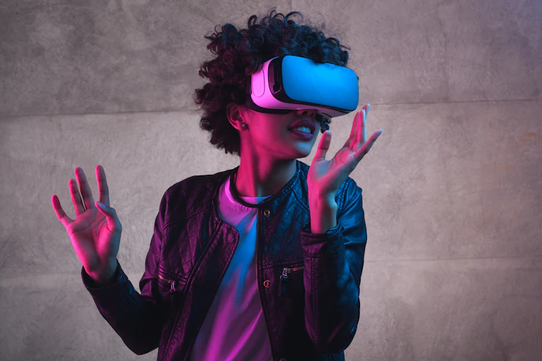 Cheerful girl with hands up wearing the virtual reality goggles