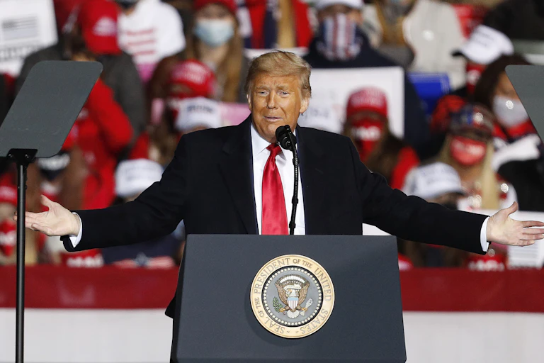 Donald Trump in front of a lectern during an election rally.