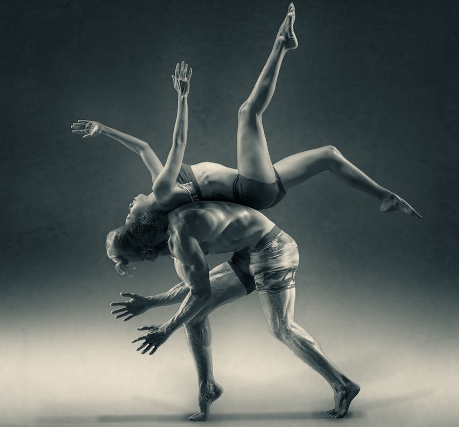 Female dancer performing on the back of a male dancer