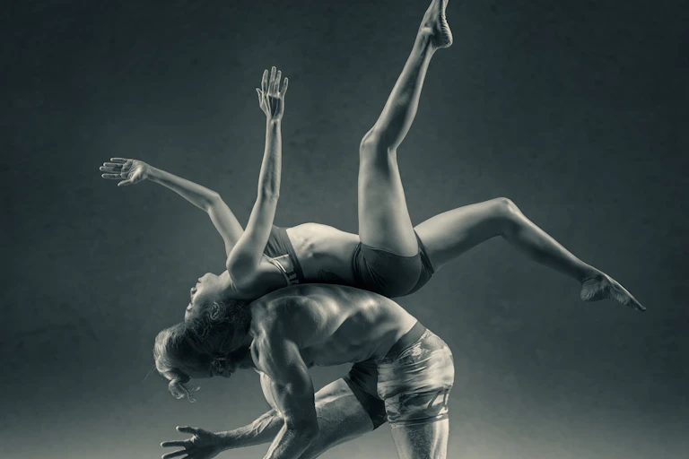 Female dancer performing on the back of a male dancer